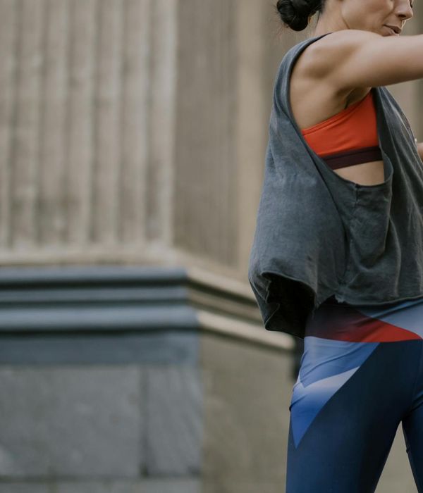 Woman in activewear performing a light cardio movement in a modern studio.
